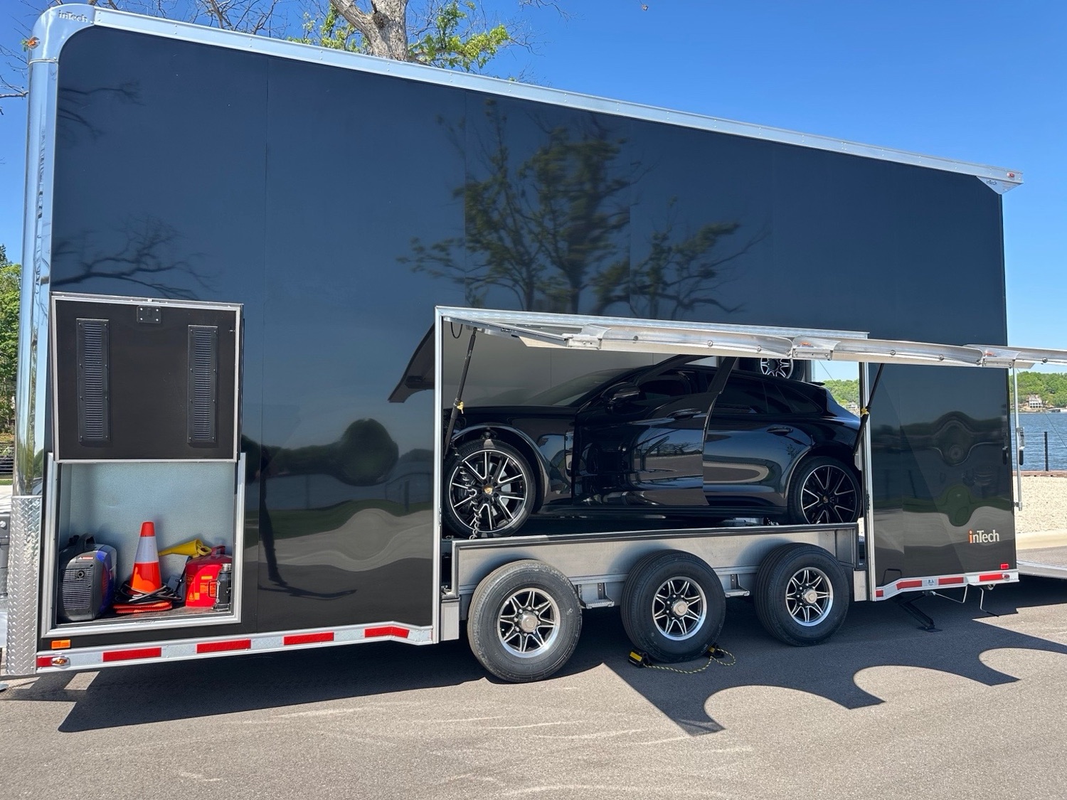 Black Porsche loaded inside an inTech enclosed stacker trailer by the lake