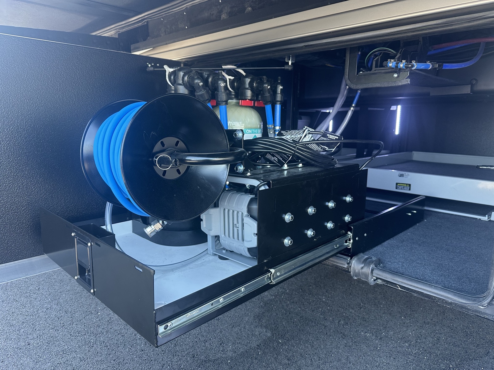 H2O Simplified water treatment system installed on a slide-out tray in a coach compartment